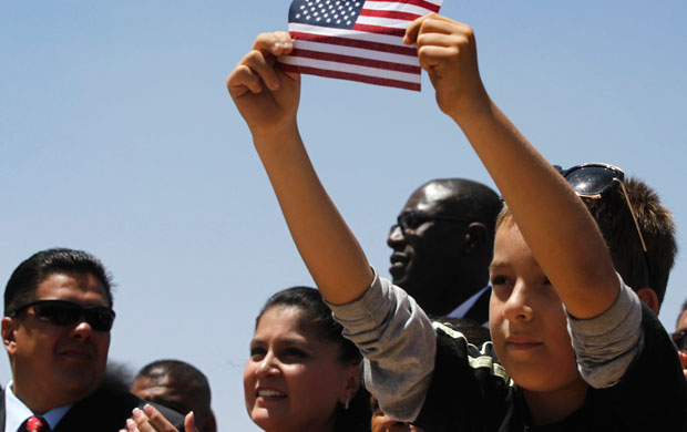A little boy holds up an American flag