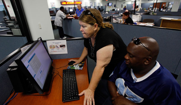 woman helping man with computer