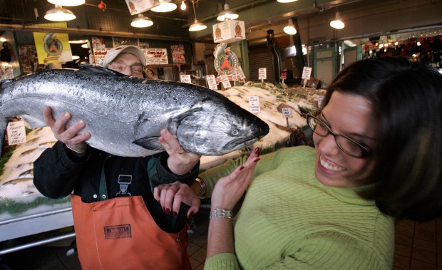 Fish vendor and customer with a 20 pound king alaskan salmon
