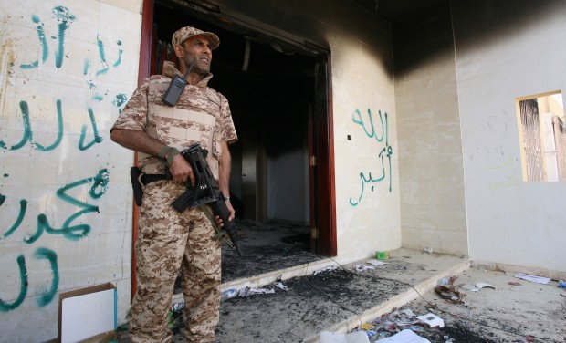 A Libyan military guard stands in front of one of the U.S. Consulate's burnt out buildings in Benghazi, Libya.