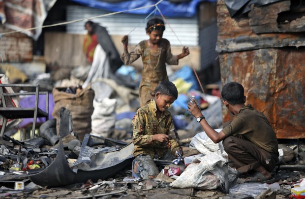 Ragpicker children collect recyclable materials at a yard on the outskirts of Jammu, India, Wednesday, Aug. 29, 2012.
