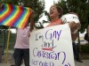 Carri Jo Anderson holds a bucket of Kuntucky Fried Chicken and a gay pride sign as she joins the protest in front of a Chick-fil-A restaurant in Pompano Beach, Fla.