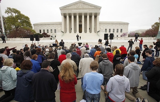 Christians kneeling outside of Supreme Court