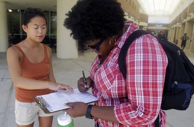 Aubrey Marks, left, helps a University of Central Florida student to register to vote in Orlando, Florida.
