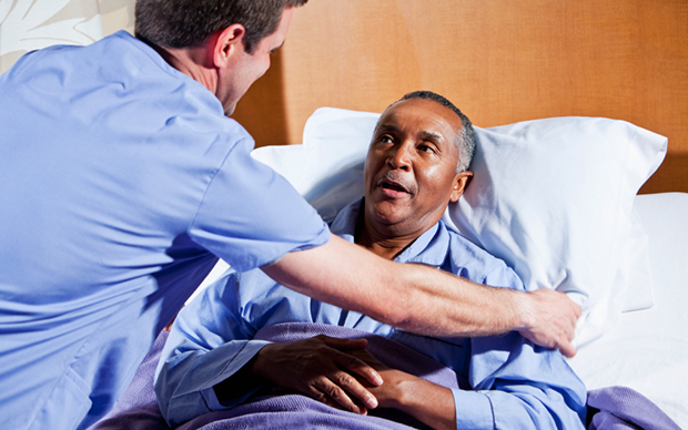 Male nurse helping African American senior patient