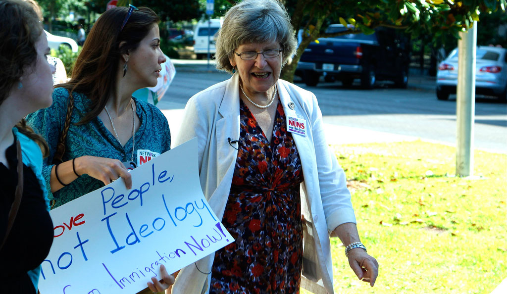 Sister Simone Campbell walks with a demonstrator