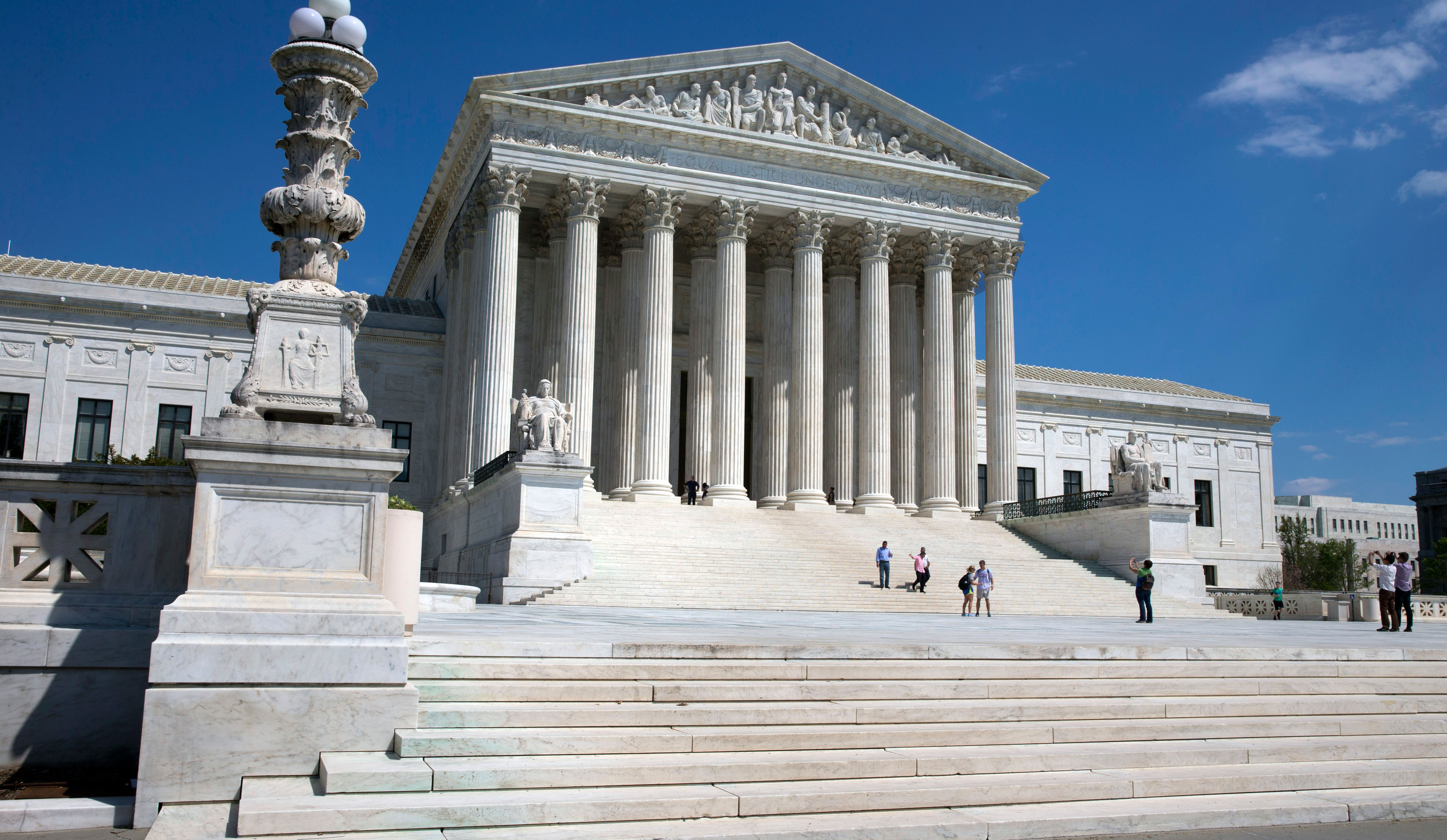People walk on the steps of the U.S. Supreme Court in Washington, D.C.