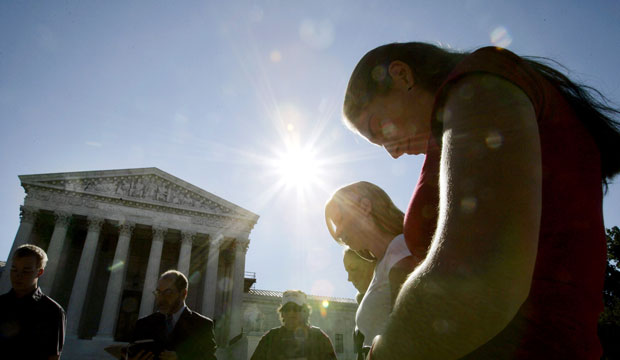 People pray in front of the Supreme Court.