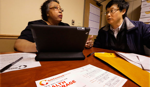 Navigator Mary Bennett, left, helps Min Lians, who is seeking help buying health insurance