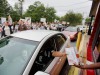 A worker hands a food order over to a customer as demonstrators march through a Burger King restaurant drive-thru