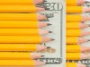 Pencils rest on a dollar bill
