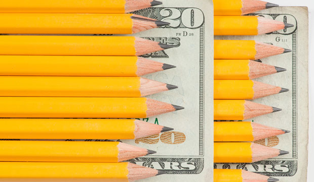 Pencils rest on a dollar bill