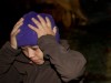 A migrant reacts after being taken into custody