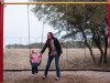 A woman plays with her daughter in a park.