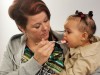 A mother feeds her daughter.