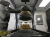 A robot paints brake drums at a factory.