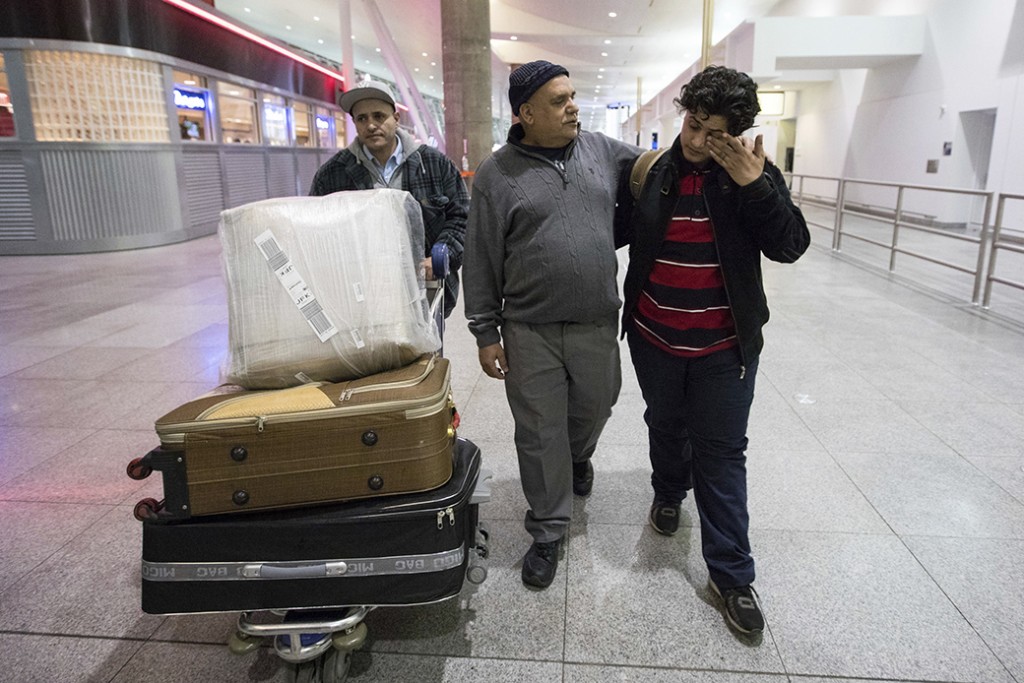A teenage boy from Yemen wipes his eyes as he walks with his father and his uncle after arrival at John F. Kennedy International Airport in New York, February 5, 2017.