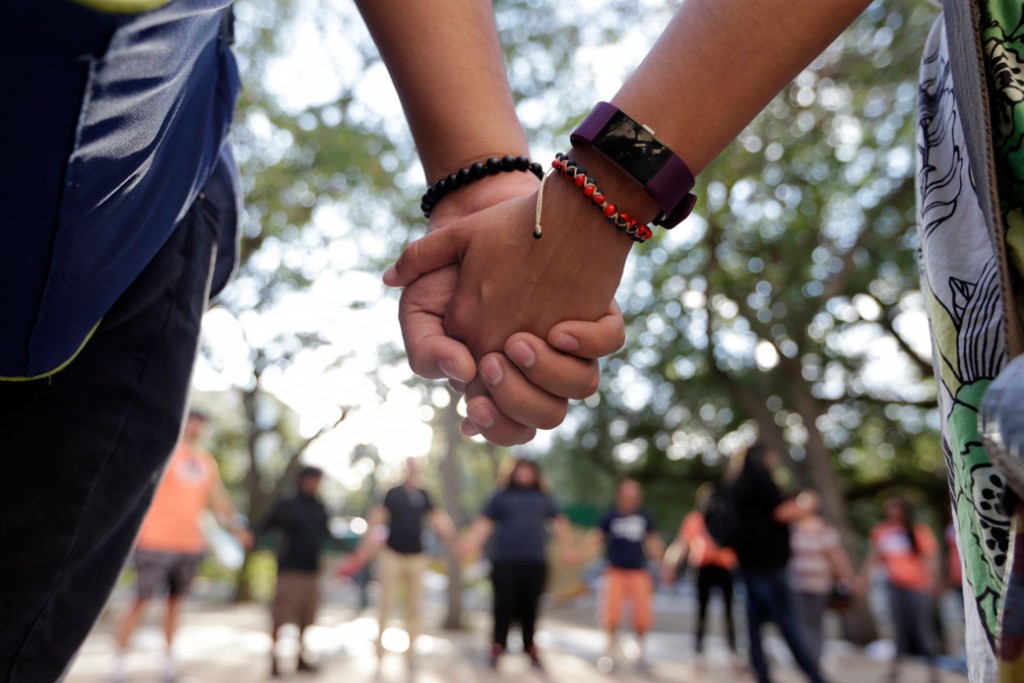 Immigrant rights supporters join hands as they demonstrate in favor of Congress passing a clean Dream Act that will prevent the deportation of young immigrants known as Dreamers working and studying in the United States, October 13, 2017, in Miami.