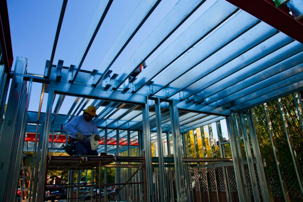 A construction worker assembles steel framing over the foundation of a new, energy-efficient home in Studio City, California, March 2013.