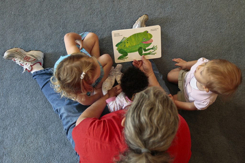 A woman reads to children as she runs her at-home day care in Virginia, July 2012.