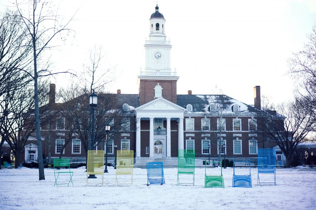 Several multicolored lawn chairs are lined up in front of Gilman Hall on the snowy Keyser quadrangle on the Homewood campus of the Johns Hopkins University in Baltimore, Maryland, January 2015.