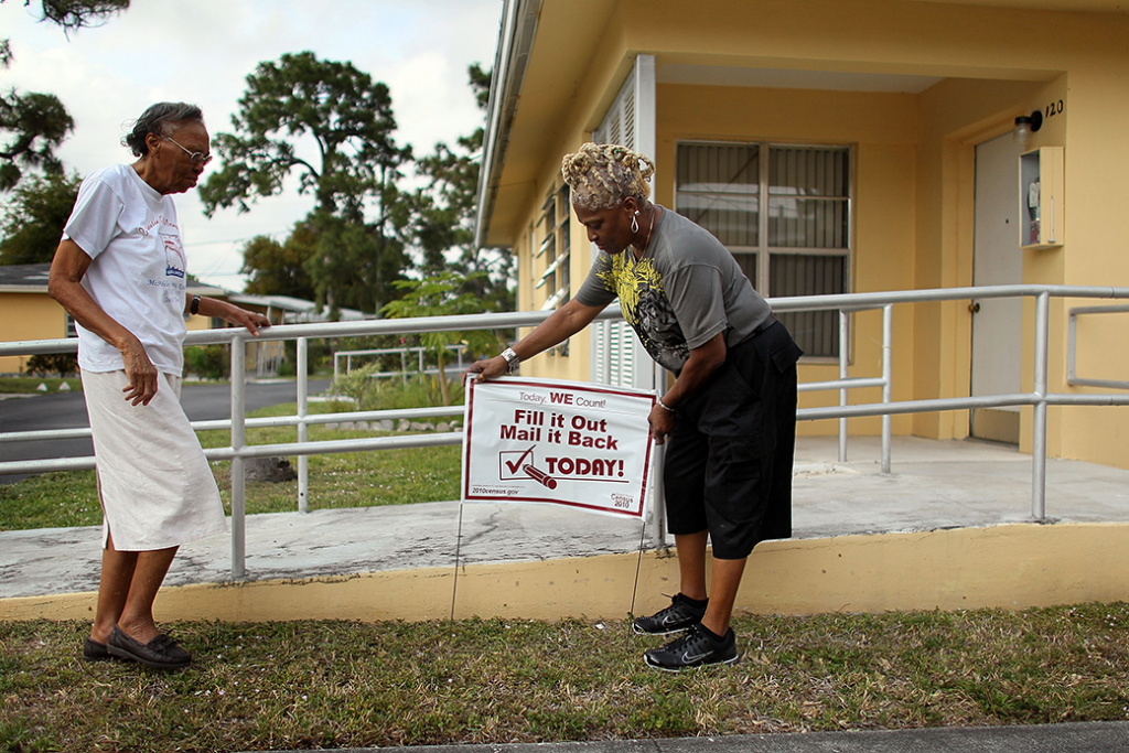A U.S. Census volunteer places a sign in front of a resident's home in Miami as part of an effort to boost mail response rates in hard-to-count communities, April 2010.