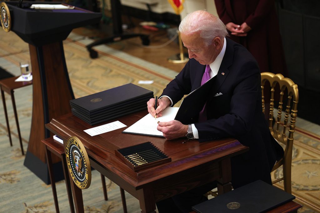 President Joe Biden signs an executive order during an event in the State Dining Room of the White House, January 21, 2021, in Washington. President Biden delivered remarks on his administration’s COVID-19 response and signed executive orders and other presidential actions.