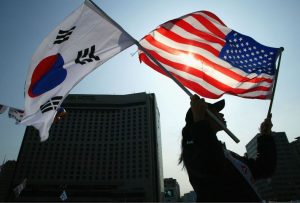 Woman holds US and South Korean flags