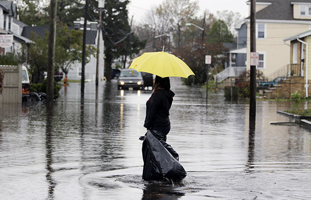 Lisa Torres walks along a flooded street to check the flood damage at her hair salon in the wake of superstorm Sandy on Tuesday, October 30, 2012, in Little Ferry, New Jersey. Sandy arrived along the East Coast and morphed into a huge and problematic system, putting more than 7.5 million homes and businesses in the dark and causing a number of deaths.