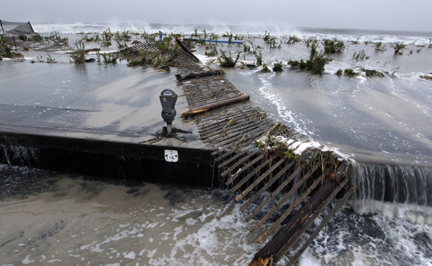 Rough surf of the Atlantic Ocean breaks over the beach and across Beach Avenue, Monday, October 29, 2012, in Cape May, New Jersey, as high tide and superstorm Sandy begin to arrive.