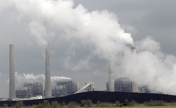 In this Wednesday, March 16, 2011, file photo, exhaust rises from smokestacks in front of piles of coal at NRG Energy's W.A. Parish Electric Generating Station in Thompsons, Texas.