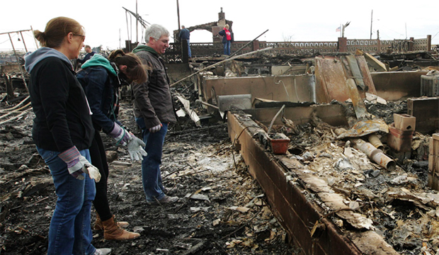 A family assesses the damage caused by a fire during Superstorm Sandy on Wednesday, October 31, 2012, in New York.