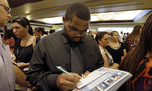 Job seeker Kelsey Devoe of Miramar, Florida, fills out a contact form at a job fair in Miami Lakes, Florida, Wednesday, August, 14, 2013.