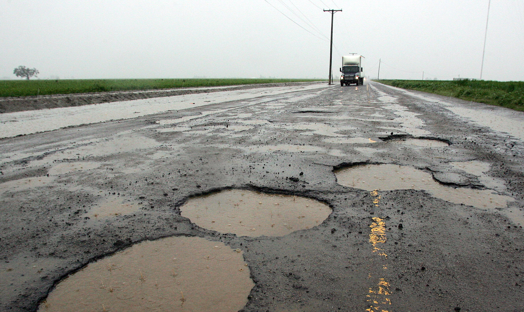 Potholes are visible on a farming back road in Tulare, California.