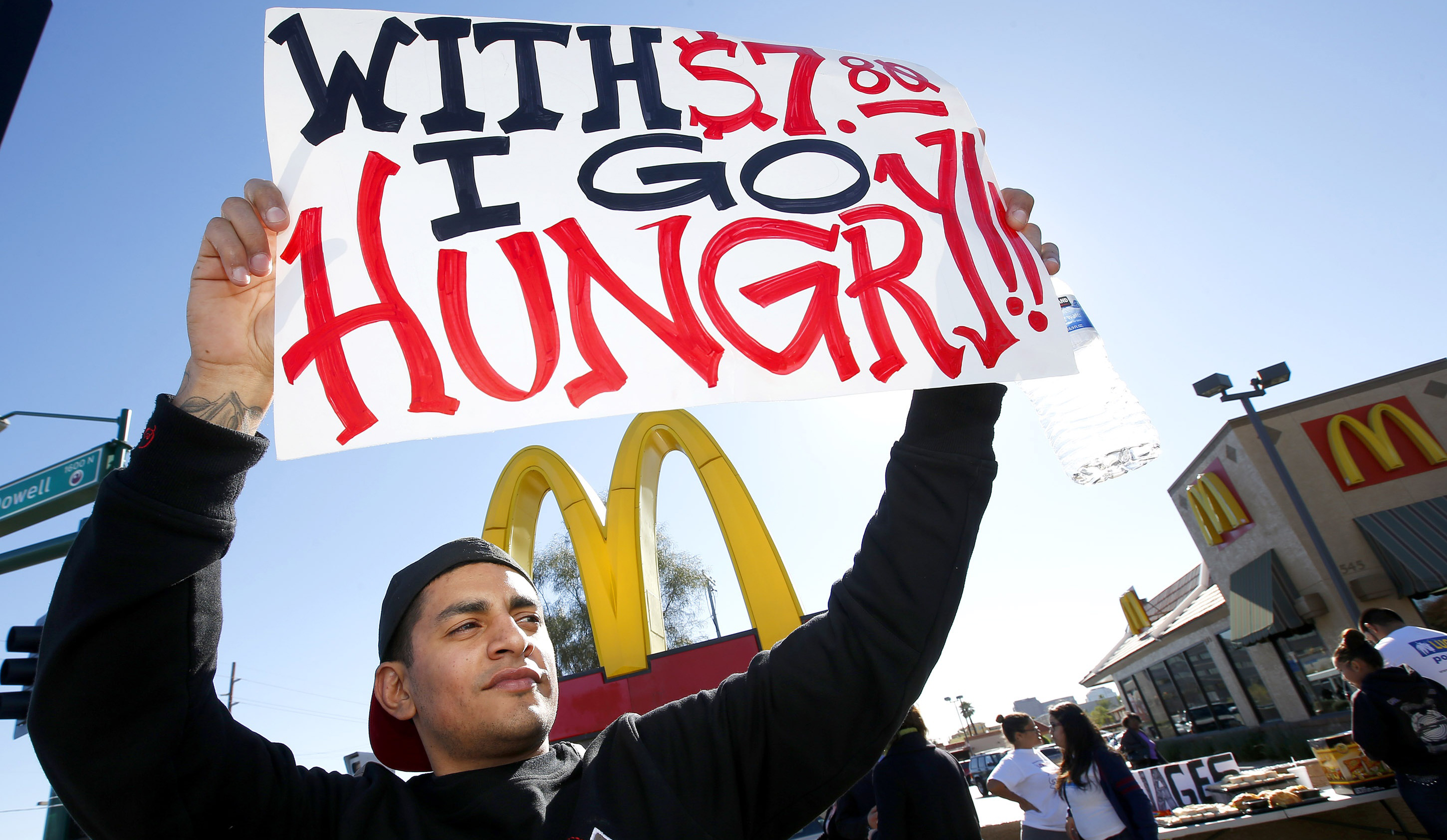 Alex Robles joins dozens of sign-holding protesters at a rally against low wages in front of a McDonald's in December 2013.