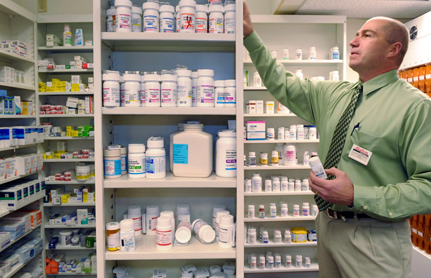 Pharmacist Salvatore Ciolino, Jr. reaches for a prescription bottle at a Gloucester, Massachusetts.