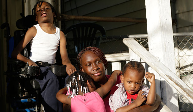 Patricia Jones is hugged by her 4-year-old daughter Pashalae Armstrong while outside her home in Newark, New Jersey, with her other children, Nature Harris and Latrell Armstrong.