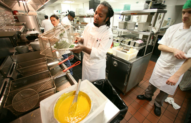 Haitian immigrant Jean Emy Pierre, head chef at Colors, a restaurant co-owned by a multinational immigrant staff, works with his kitchen staff as they prepare for dinner in New York.