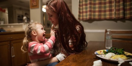 A mother eats dinner with her daughter