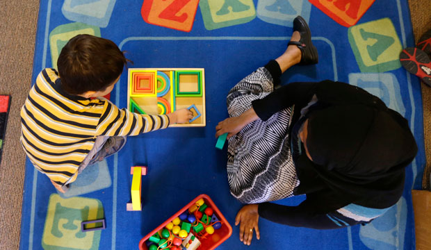 child and preschool teacher play