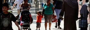 Pedestrians walk along 144th Street between 7th Avenue and Frederick Douglass Boulevard