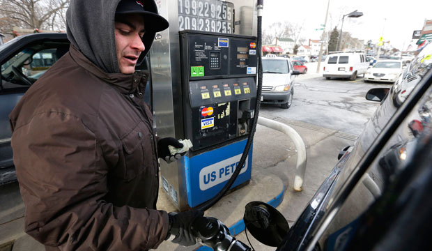 A motorist fills up his car's gas tank.