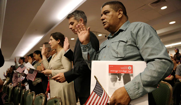 New U.S. citizens recite the Oath of Allegiance while participating in a naturalization ceremony, New York, July 2014.