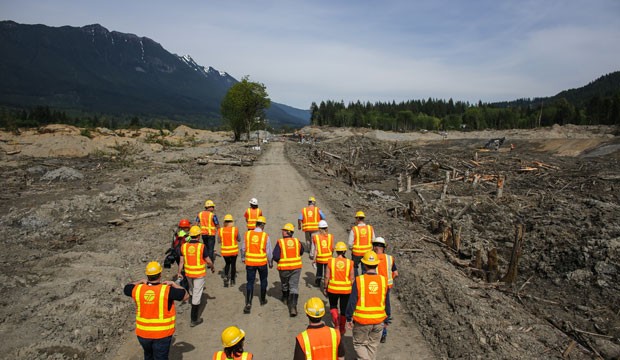 Officials walk into the mudslide debris field in Washington state.