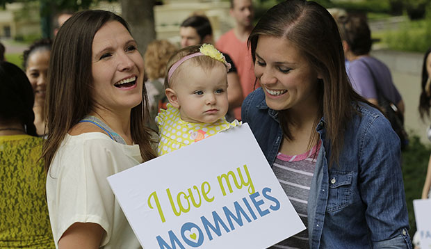 A married couple is pictured with their infant daughter, July 2014.