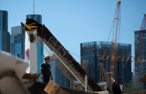A worker stands on the site of a new development project at the central business district of Beijing, China, in June 2015.