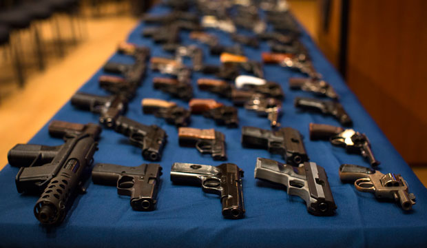 Nearly 100 confiscated illegal firearms—many from out-of-state sources, notably South Carolina—rest on a table before a press conference on October 12, 2012, in New York City.