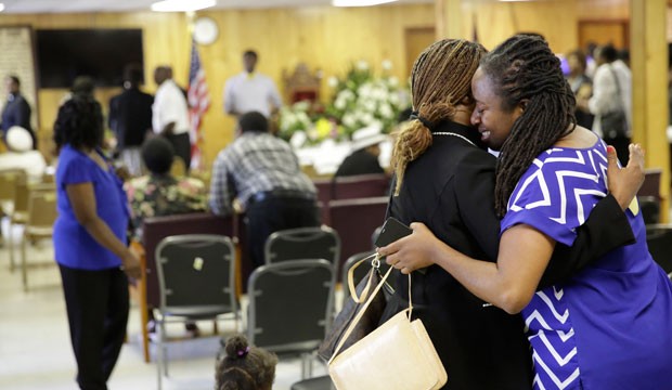 A reverend embraces a church member who is grieving.