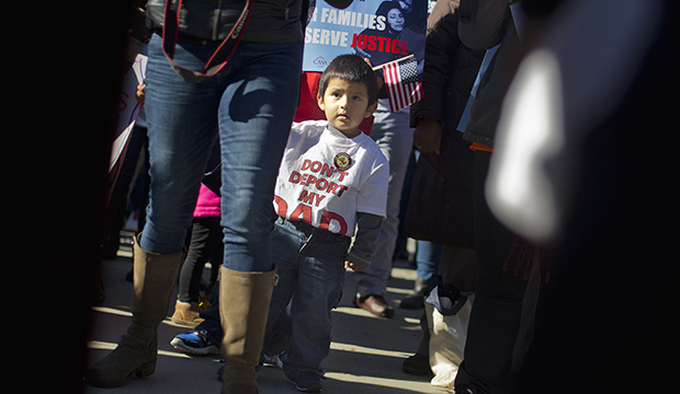 A 2-year-old watches his parents take part in a rally for immigration reform at the Supreme Court in Washington, November 20, 2015, on the one-year anniversary of President Barack Obama's announcement concerning DAPA.