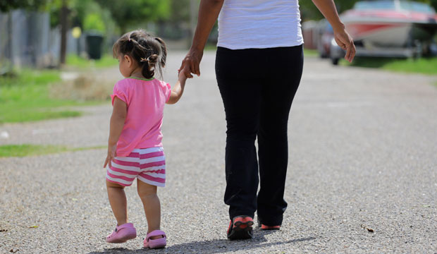 A woman walks with her 2-year-old daughter in Sullivan City, Texas, on September 16, 2015.